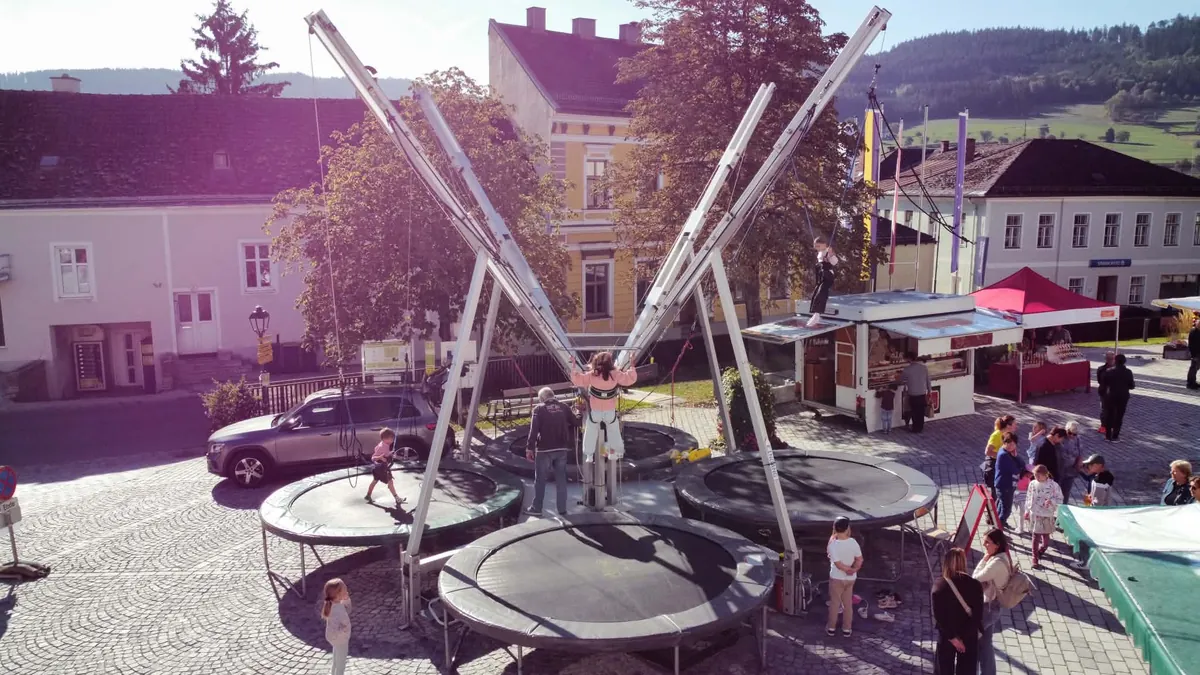 Bungee-Trampolin auf einem Kirtagsplatz, von oben fotografiert